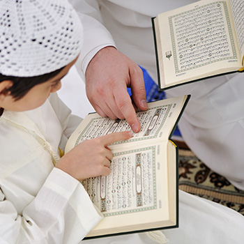 muslim arabic father son reading koran